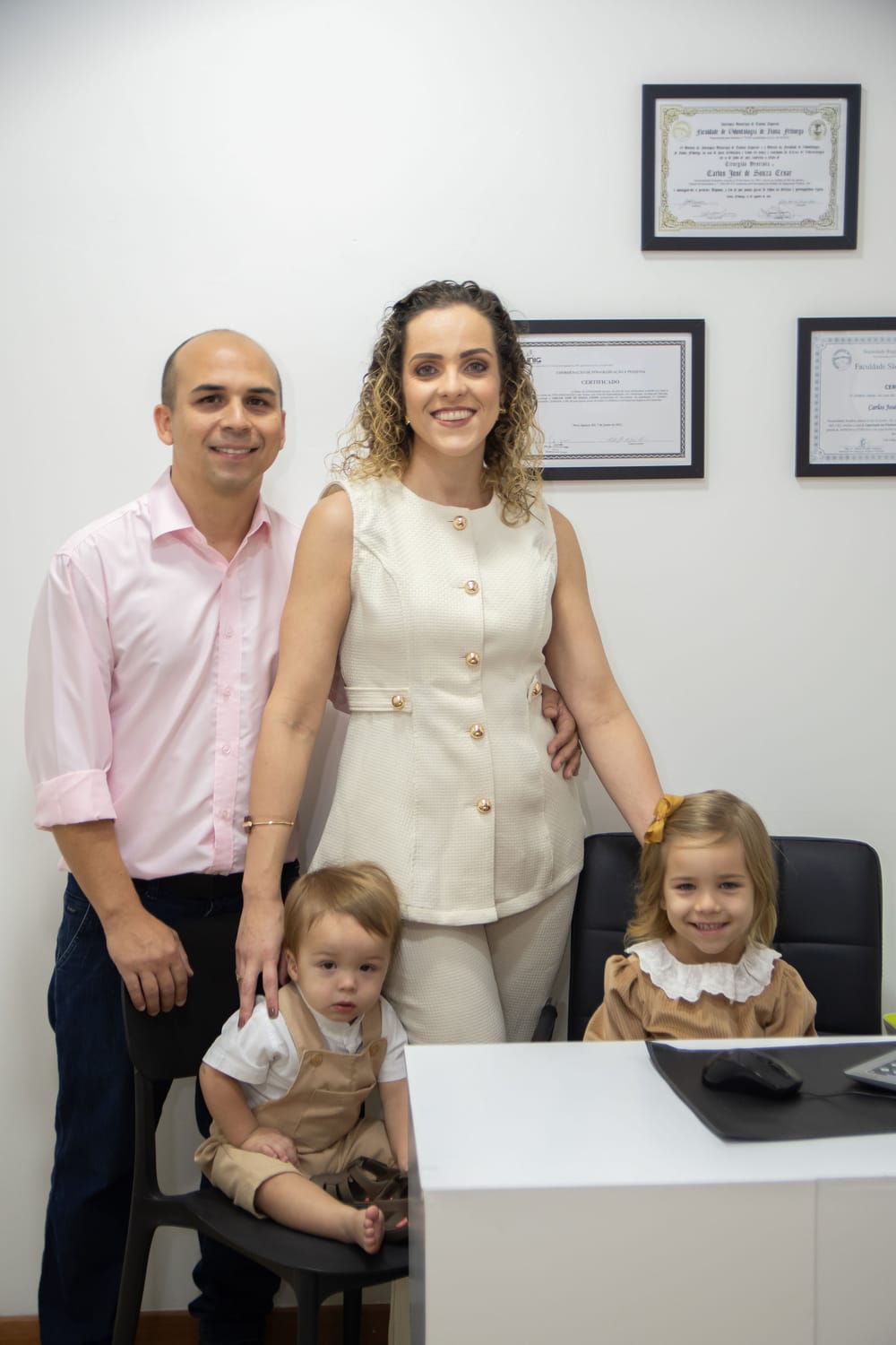 A família fundadora da clínica no consultório, com os diplomas ao fundo